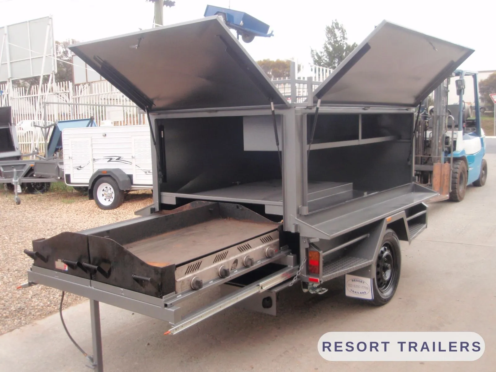 BBQ trailer opened up with the hotplate slid out — built by Resort Trailers