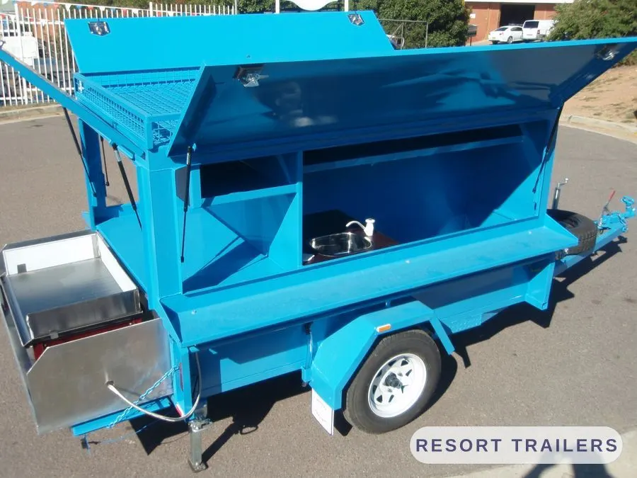 Blue BBQ trailer with the servery and hotplate open — built by Resort Trailers