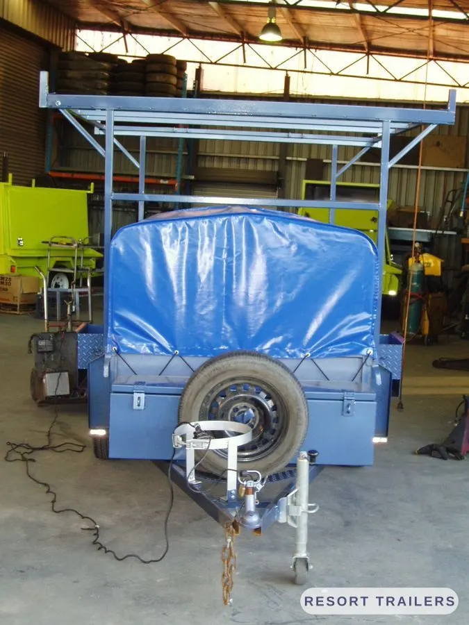 Canoe rack trailer with spare wheel and front toolbox — built by Resort Trailers