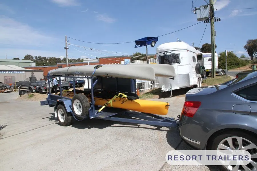 Loaded kayak trailer hitched to the tow car — built by Resort Trailers