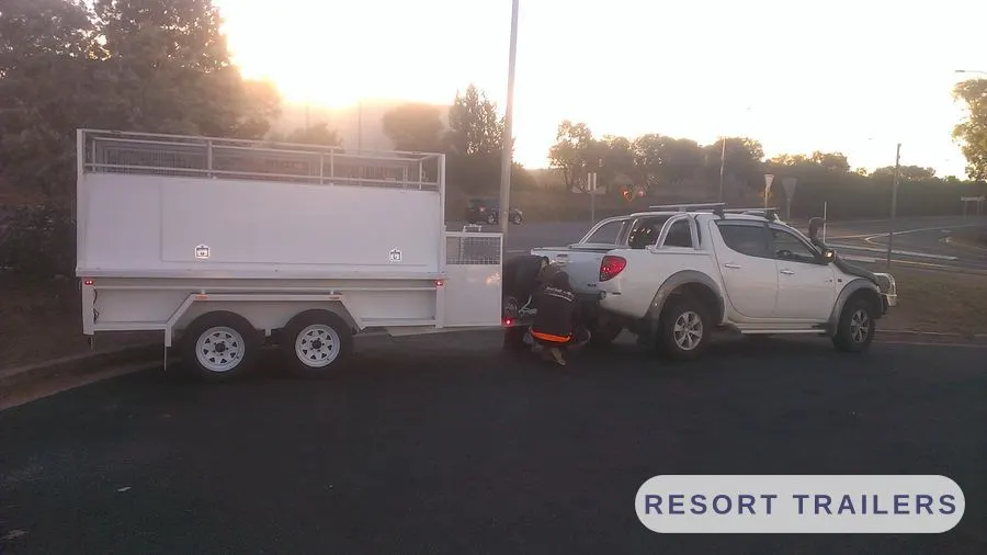 Canopy trailer photographed at dusk with the tow vehicle — built by Resort Trailers