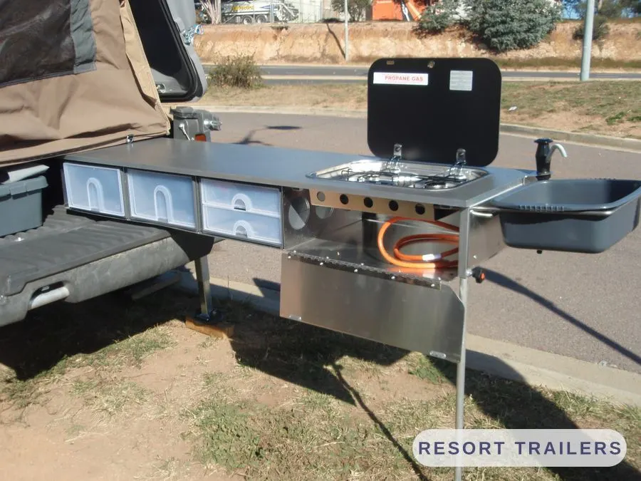Slide-out camp kitchen with sink, stove and drawers — built by Resort Trailers