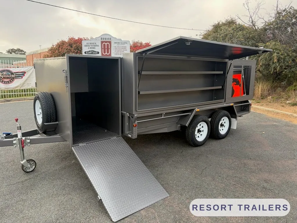 Enclosed mowing trailer with side and rear ramps