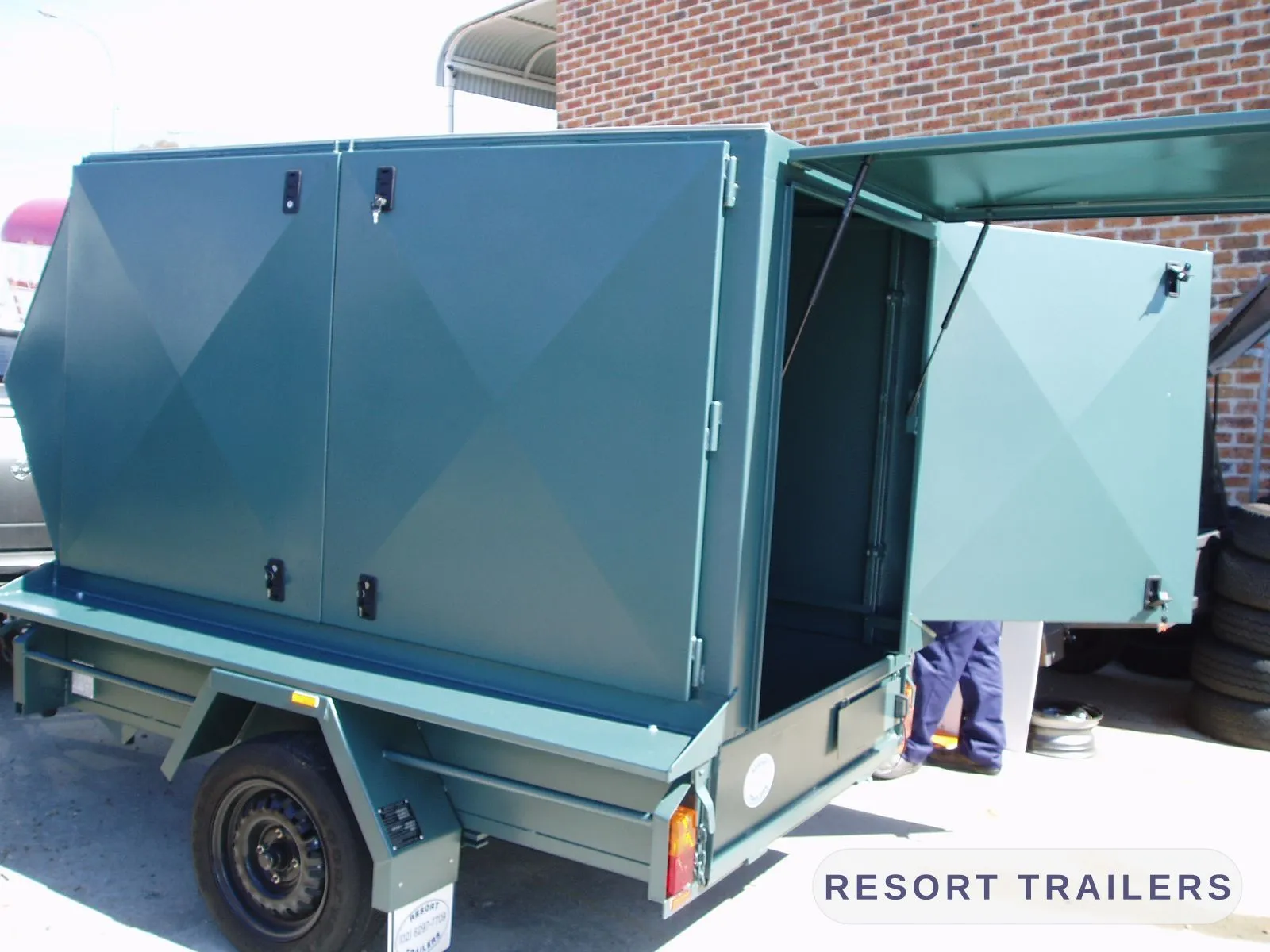 Fully enclosed trailer with twin barn doors in teal — built by Resort Trailers