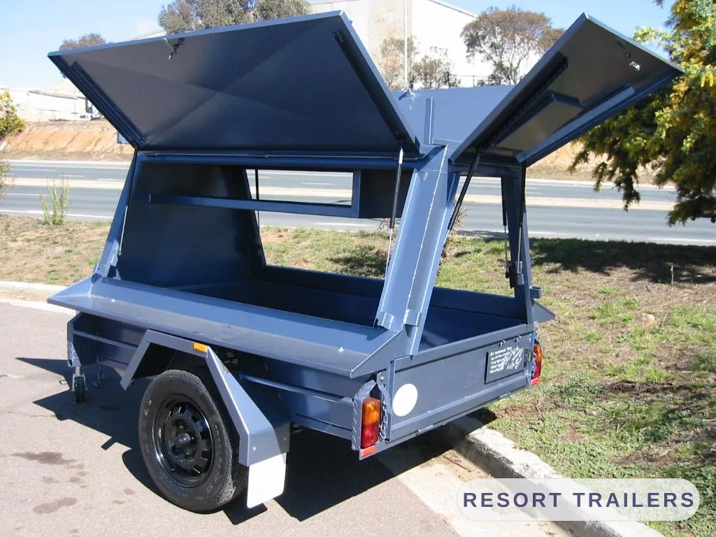 Both gull-wing lids raised on a canopy trailer — built by Resort Trailers