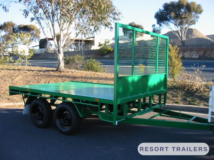 Green flat deck trailer with a mesh headboard — built by Resort Trailers