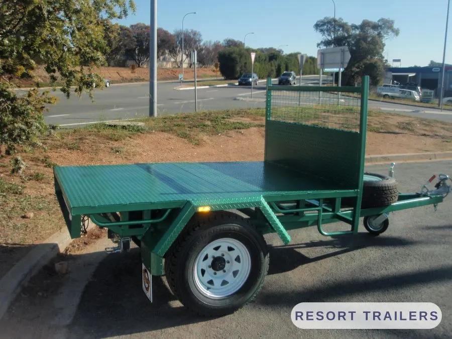 Single-axle green table top with a steel headboard — built by Resort Trailers